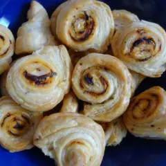 Złociste ślimaczki z ciasta francuskiego, pieczone do perfekcji, kuszą apetycznym wyglądem.