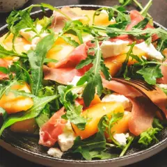 Orzeźwiająca sałatka z melonem, rukolą, mozzarellą i szynką parmeńską. Idealna na letnie dni.