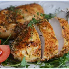 Soczysty filet z kurczaka z piekarnika, przyprawiony ziołami, podany z pomidorami i rukolą.
