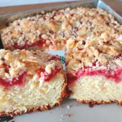 Szybkie ciasto z malinami i kruszonką, pokrojone na talerzyku. Idealne na letnie popołudnie.