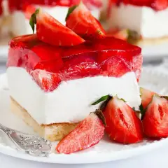 Pyszny biszkopt z truskawkami i mascarpone, oblany galaretką. Idealny deser na letnie popołudnie.