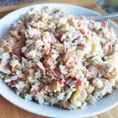 Pyszna sałatka z tuńczykiem, ryżem, warzywami i majonezem, podana na białym talerzu. Idealna na szybki obiad.