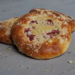 Pyszna drożdżówka z kruszonką i malinami, pachnąca domowym ciepłem.