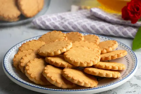 Stos ciasteczek na talerzu, idealnych do kawy. Pyszny przepis na ciastka, który warto wypróbować.