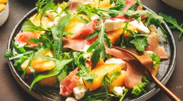 Orzeźwiająca sałatka z melonem, rukolą, mozzarellą i szynką parmeńską. Idealna na letnie dni.