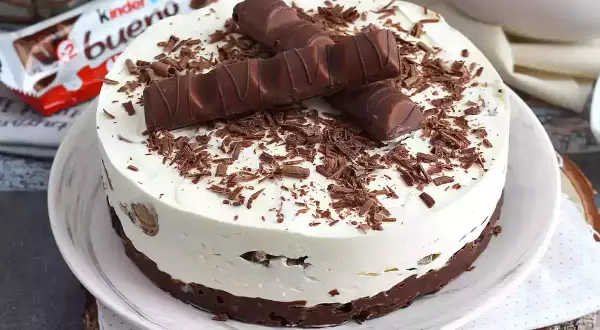 Pyszny sernik Kinder Bueno, udekorowany kawałkami batoników i czekoladową posypką. Idealny deser dla fanów słodkości.