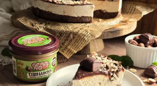 Pyszne ciasto z mascarpone, udekorowane czekoladą i orzechami. Obok słoik pasty z orzechów laskowych.