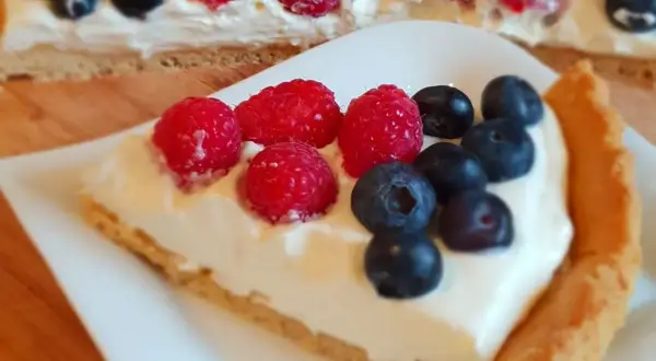 Kawałek pysznej tarty z kremem i owocami leśnymi. Ten najlepsza tarta przepis to marzenie!