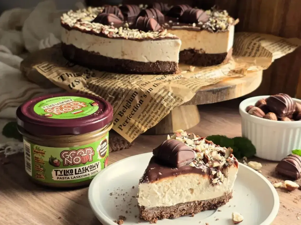 Pyszne ciasto z mascarpone, udekorowane czekoladą i orzechami. Obok słoik pasty z orzechów laskowych.