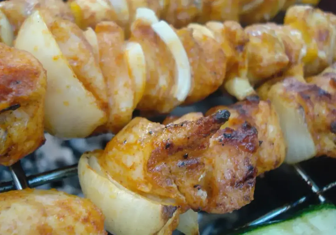 Szaszłyki z kurczaka i cebuli, idealnie przypieczone na grillu. Dowiedz się, jak pokroić cebulę do szaszłyków, by uzyskać taki efekt.