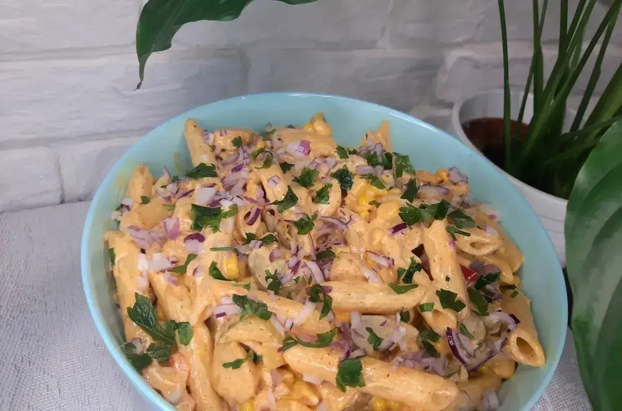 Pyszna sałatka gyros z makaronem penne, kukurydzą i czerwoną cebulą, polana kremowym sosem.