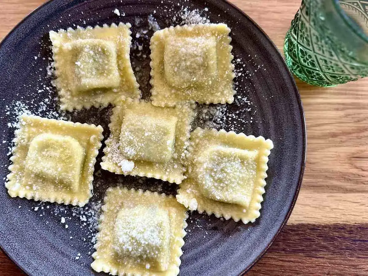 Pyszne ravioli z serem i szpinakiem, posypane parmezanem. Idealne z lekkim sosem lub masłem. Zastanawiasz się, ravioli z czym podawać? Oto inspiracja!