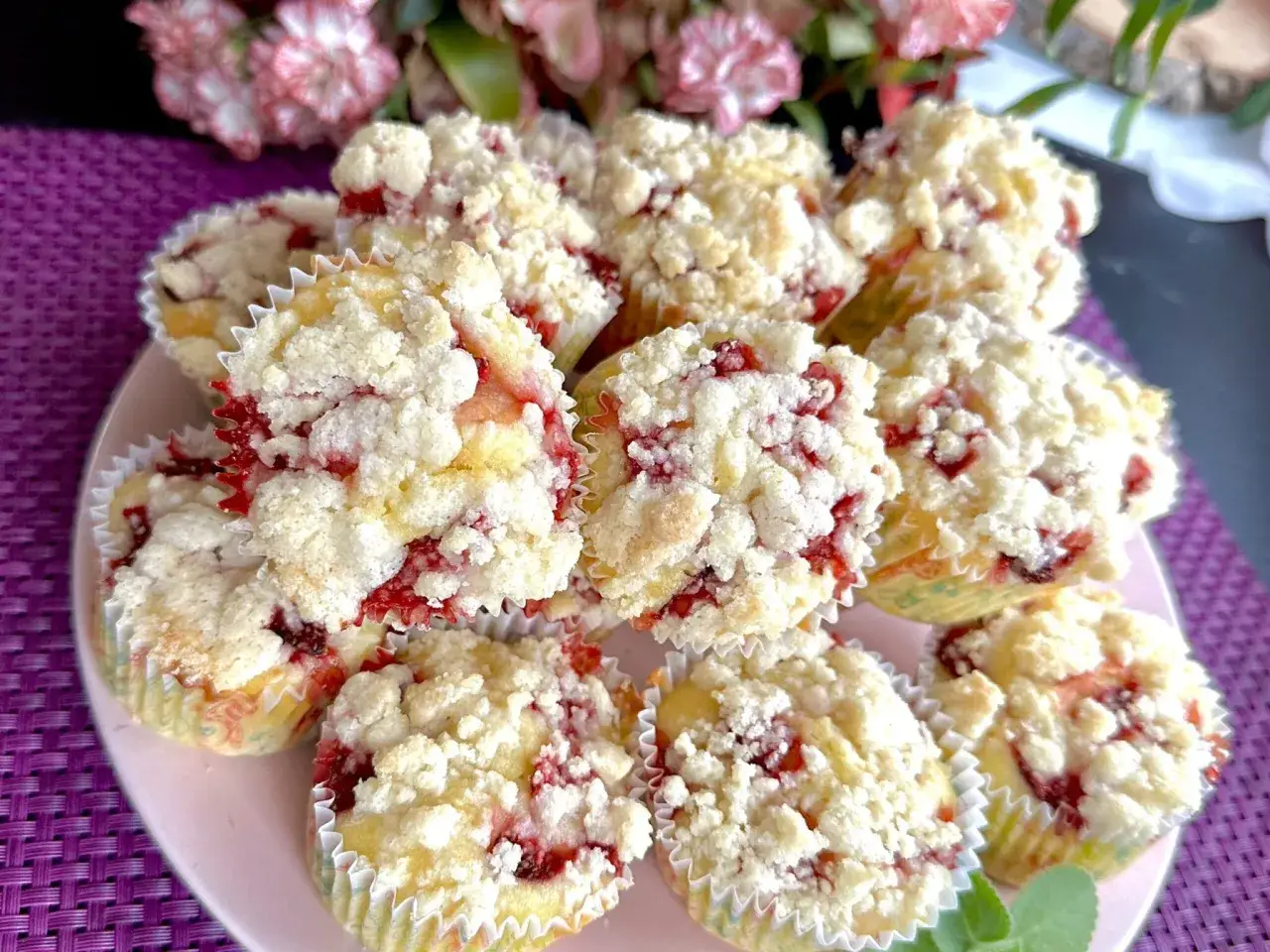 Pyszne muffinki z truskawkami, posypane kruszonką, kuszą swoim wyglądem.
