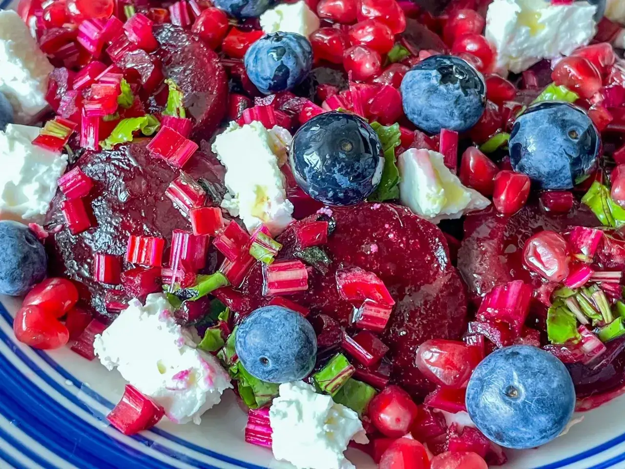 Kolorowa sałatka z burakiem, jagodami, granatem i serem feta. Pyszne połączenie smaków i kolorów.
