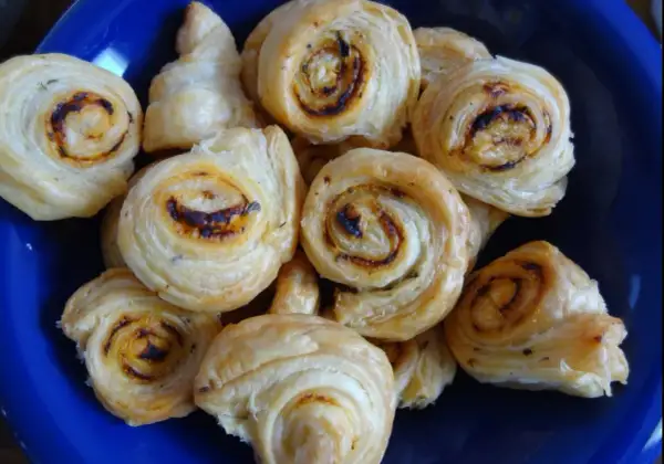 Złociste ślimaczki z ciasta francuskiego, pieczone do perfekcji, kuszą apetycznym wyglądem.