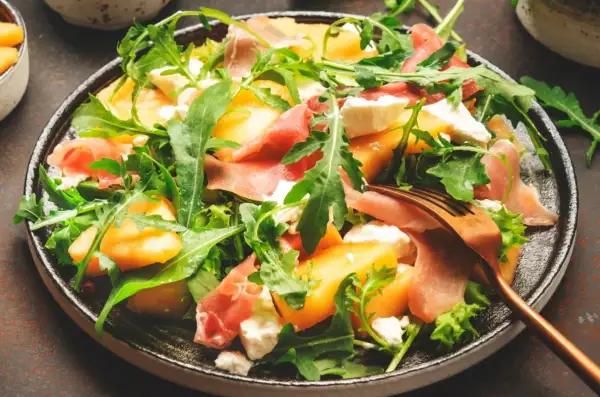Orzeźwiająca sałatka z melonem, rukolą, mozzarellą i szynką parmeńską. Idealna na letnie dni.