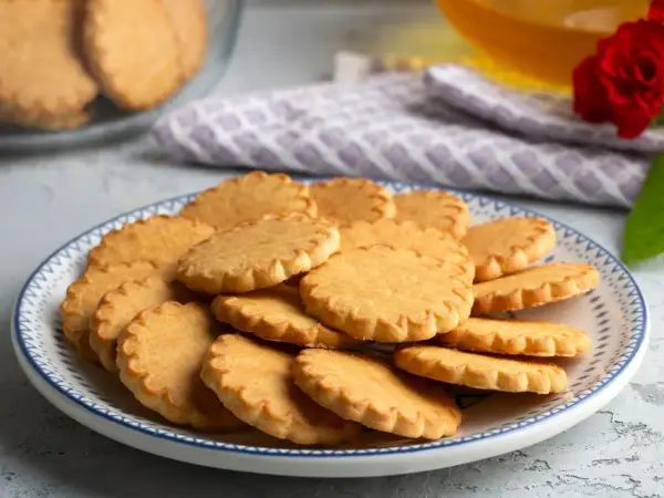 Stos ciasteczek na talerzu, idealnych do kawy. Pyszny przepis na ciastka, który warto wypróbować.