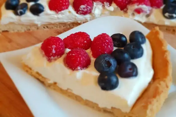 Kawałek pysznej tarty z kremem i owocami leśnymi. Ten najlepsza tarta przepis to marzenie!