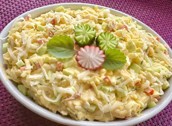 Pyszna sałatka z makaronem orzo i jajkiem, z dodatkiem ogórka, papryki i sera. Udekorowana wyciętymi z ogórka kwiatkami.
